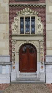 901916 Gezicht op een zijingang van het Muntgebouw (Leidseweg 90) te Utrecht, met naast de deur gevelstenen met de ...